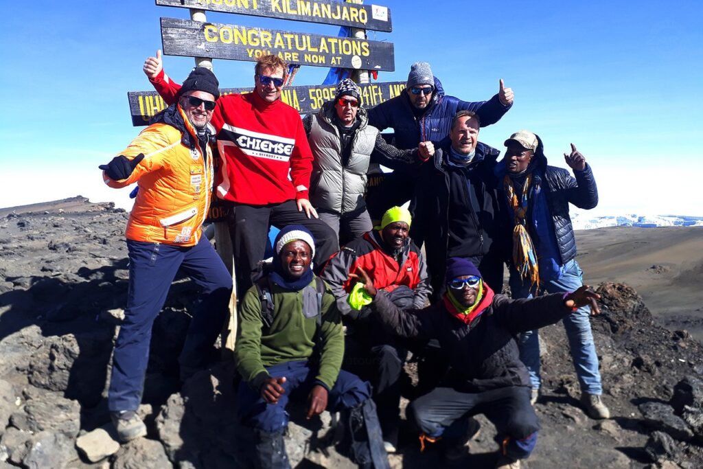 people taking a group picture at kilimanjaro hight