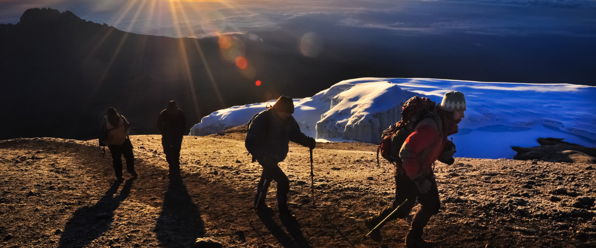 Climbers trekking on Mount Kilimanjaro with Uhuru Peak in the background